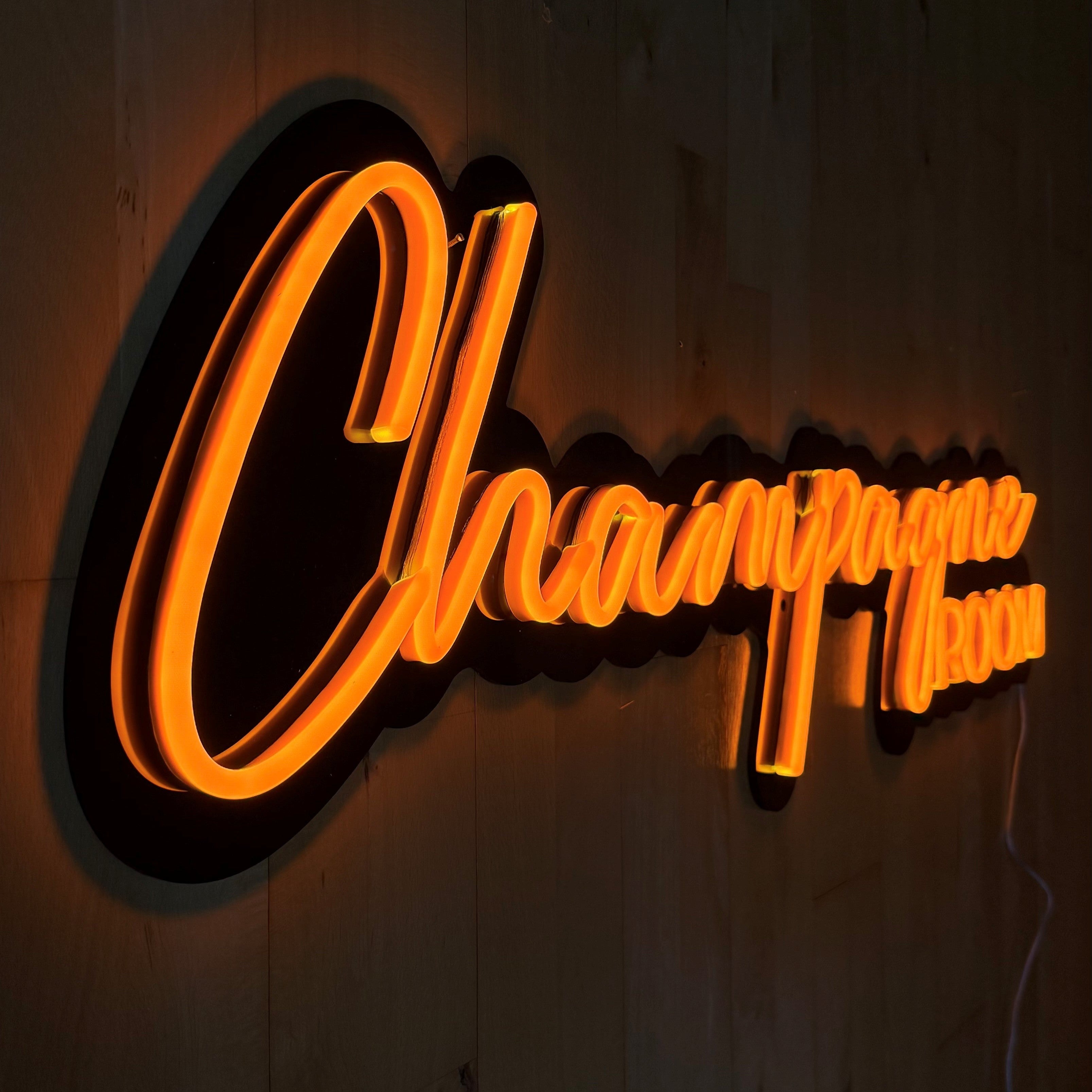 LED-neonskilt «ChampagneROOM» nærbilde, oransje lys på sort skilt.