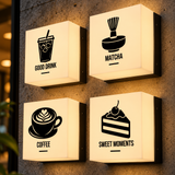 Veggkube med logo: fire veggmonterte kubelamper med kaffe-, matcha- og kakeikoner