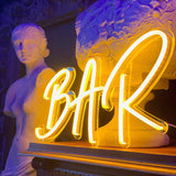 Skap en levende atmosfære med vårt 'bar' led neonskilt, som er perfekt for enhver cocktailbar eller samlingspunkt. Dette skiltet kombinerer strålende farger og moderne design for å belyse og forvandle ethvert innendørs miljø til et stilig og innbydende rom.